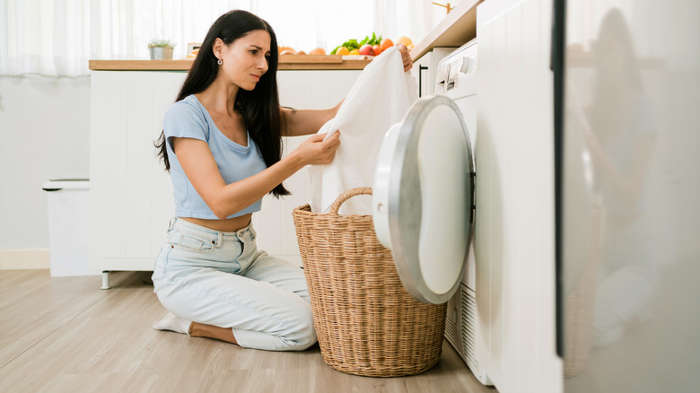 A woman looking concerned as she inspects a towel.
