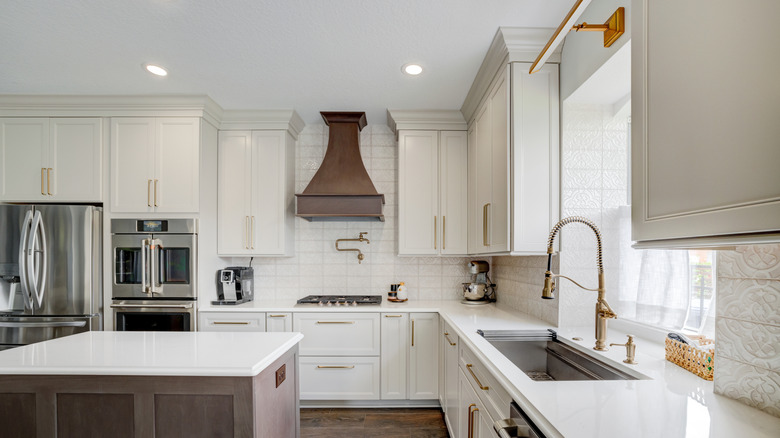 A modern all-white kitchen with stainless appliances.