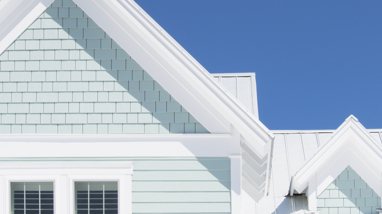 A house with white metal roof and teal siding