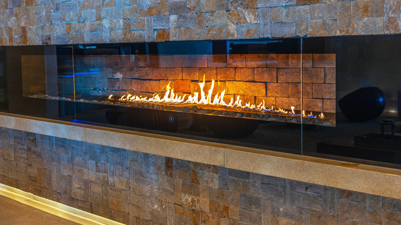 A linear fireplace surrounded by bricks