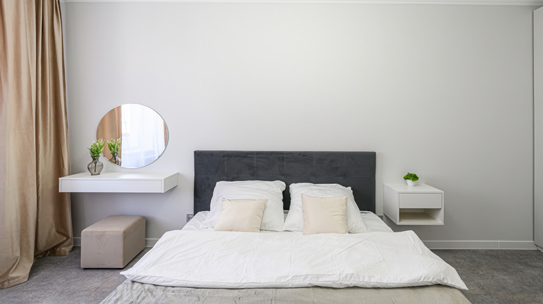 A bed with a floating nightstand and a floating vanity on either side.