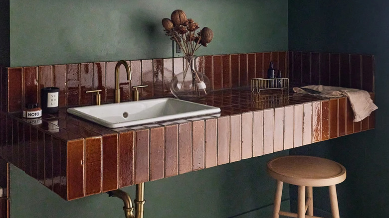 A modern bathroom sink and backsplash decorated with glazed thin brick tile.