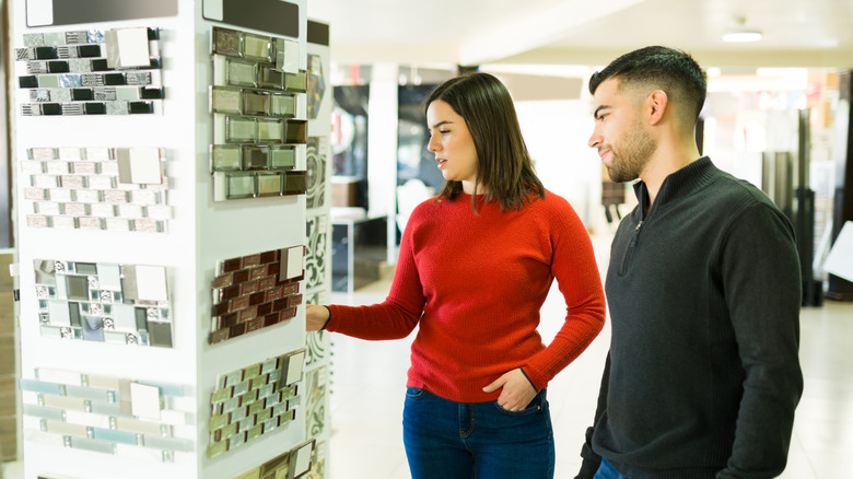 A couple shopping for tiles in a bathroom renovation supply store.