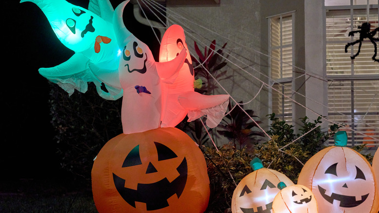 Inflatable ghosts and jack-o-lanterns outside a home on the yard