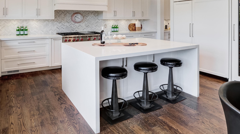 Closeup of a row of backless stools under a counter