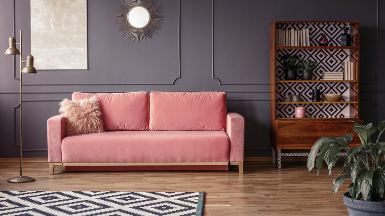 Pink couch against gray/eggplant wall