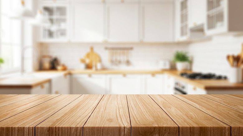 An out-of-focus kitchen with a wood counter