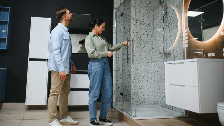 Couple inspecting shower display in design showroom.