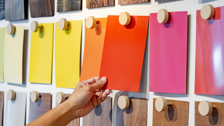 Hand picking a paint color swatch.