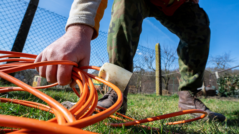 Man holding coiled extension cord