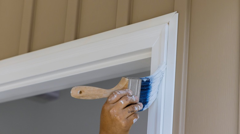 man painting door trim