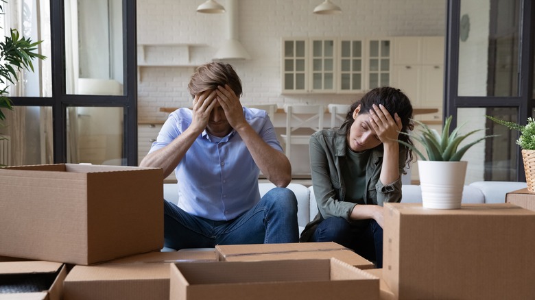 Stressed homeowners surrounded by boxes