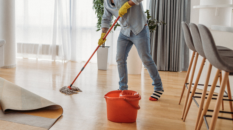 man mopping with bucket