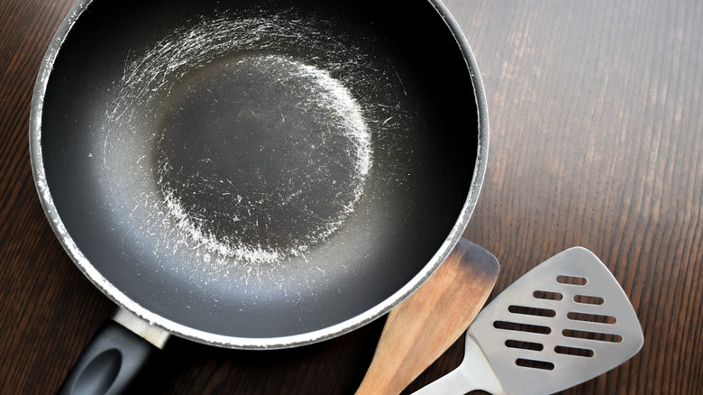A black non-stick pan that's very scratched up at the bottom