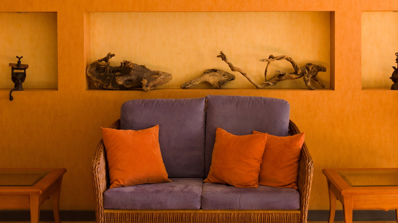 Orange living room with purple sofa and orange throw pillows