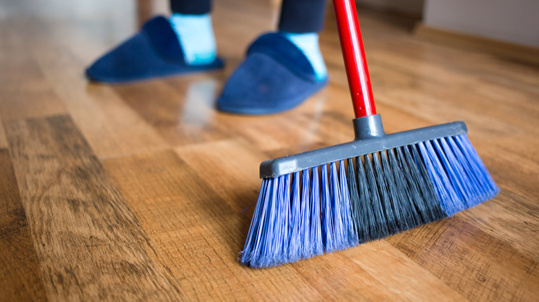 Person sweeping hardwood floor 