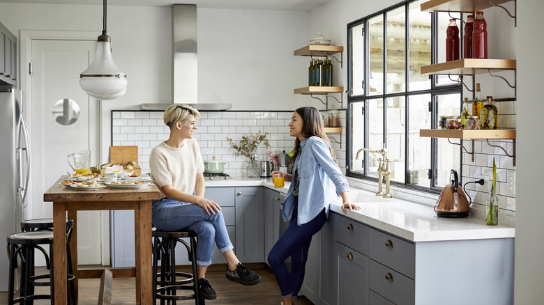 Two people chatting in a minimalist kitchen