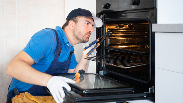 Worker repairing oven