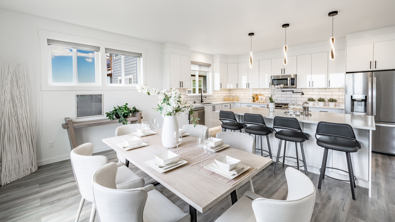 Modern white kitchen with greige vinyl flooring and dark counter stools