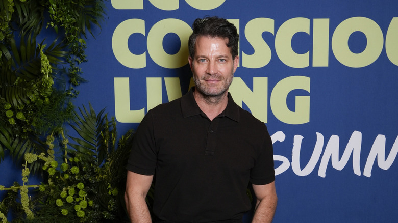 Nate Berkus smiling in front of a blue backdrop
