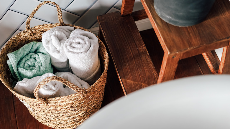 White and light blue towels rolled in a woven basket