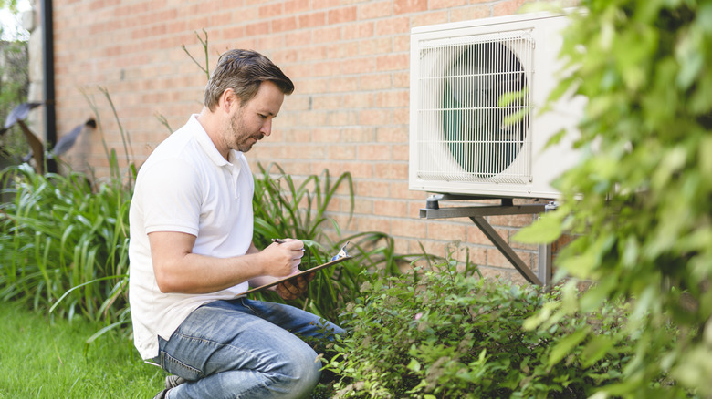 A technician inspecting a home air conditioning unit