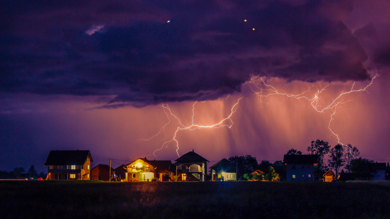 A scene of houses beneath a lightning storm