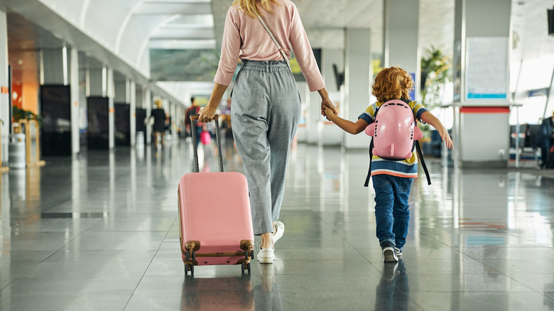 mother and child walking with suitcase