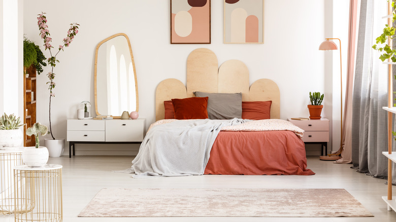 uniquely shaped mirror next to bed