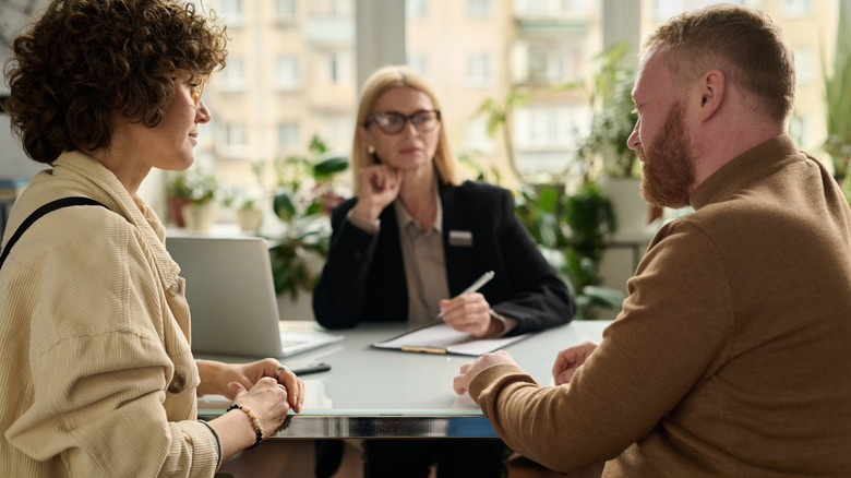 A couple speaks to each other while applying for a loan