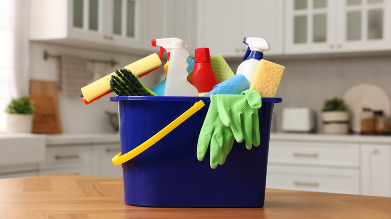 A caddy full of cleaning products including spray bottles and brushes