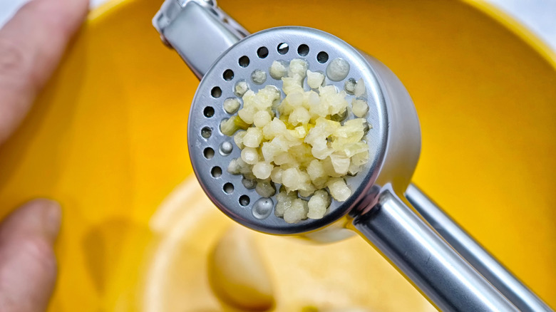 Garlic being pushed through a garlic press