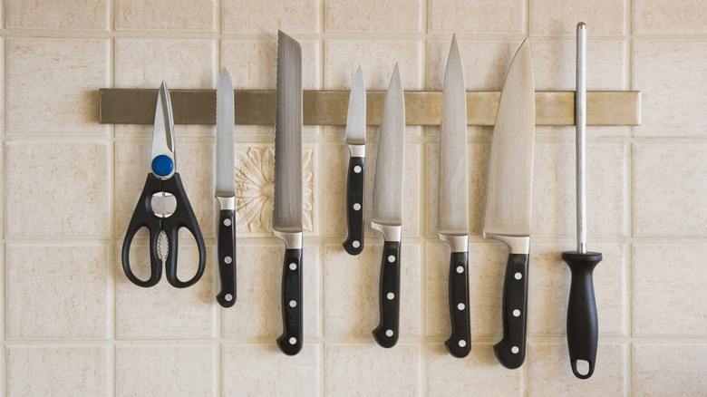 Knives hanging on a magnetic rack on the wall