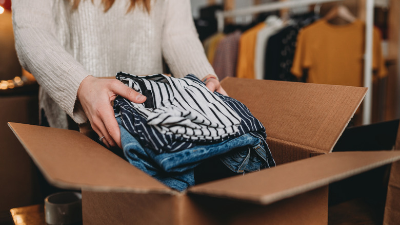 Person putting clothes in cardboard box