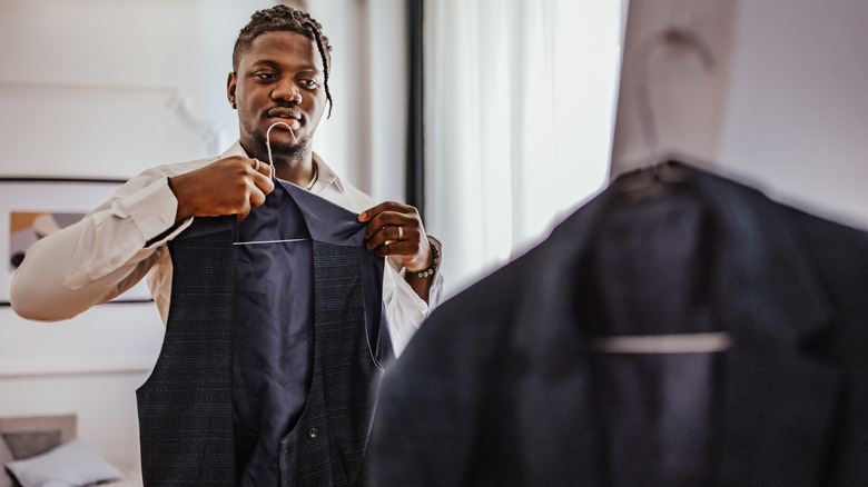 Man looking at suit vest in mirror