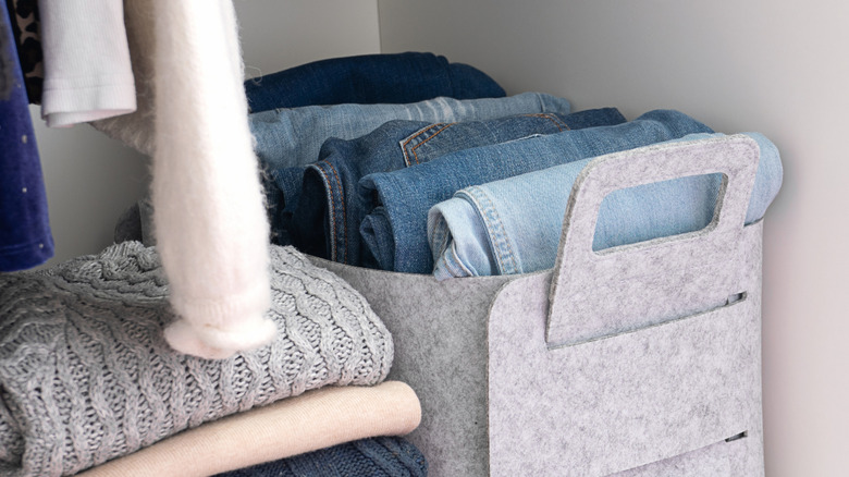 Jeans in a storage box on a closet shelf