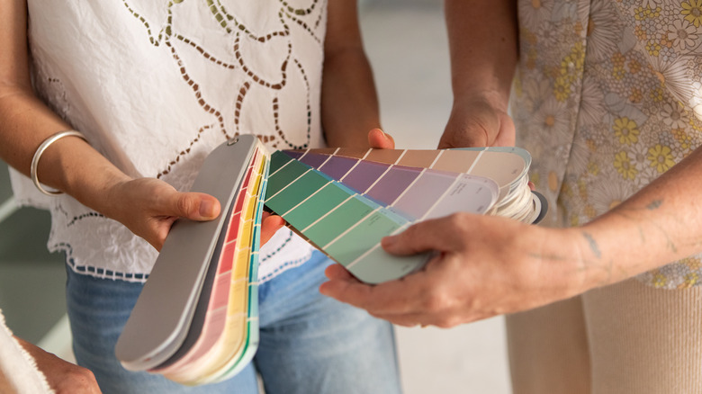 Hands holding a series of paint swatches