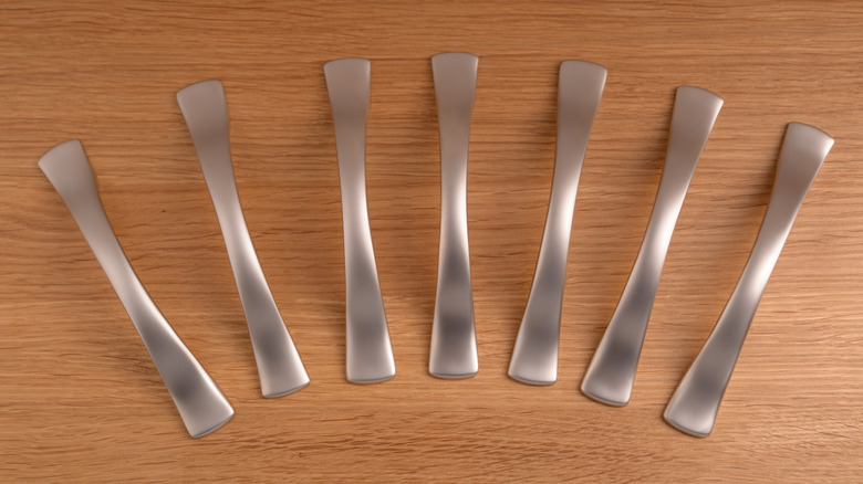 Row of satin nickel handles on a wood surface