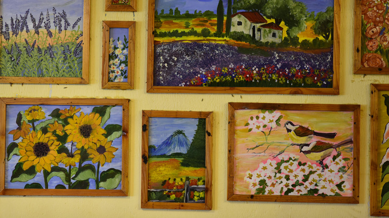 Bright, colorful paintings on a yellow wall
