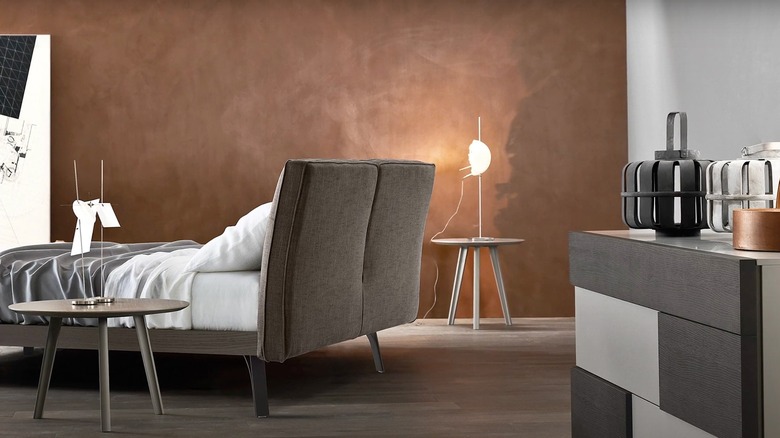 bedroom with bed in center and desk behind it