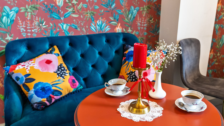 Colorful breakfast nook featuring pattern pillows and wallpaper, and furniture with vibrant colors