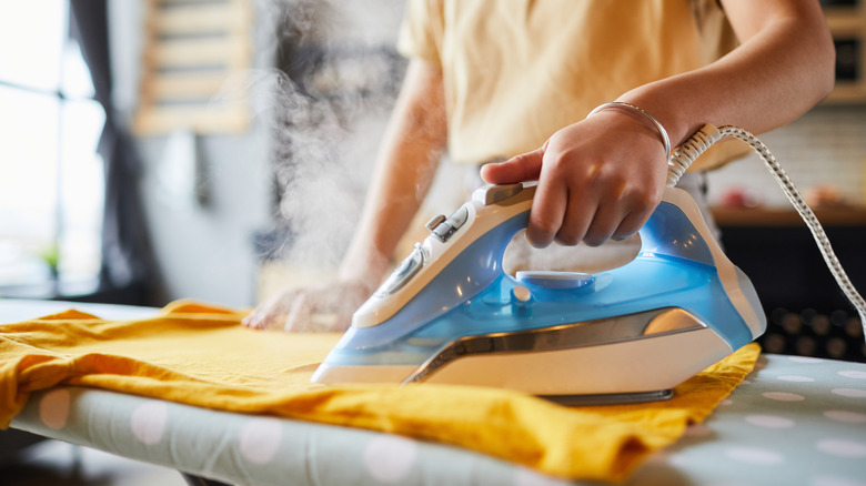 woman ironing orange shirt