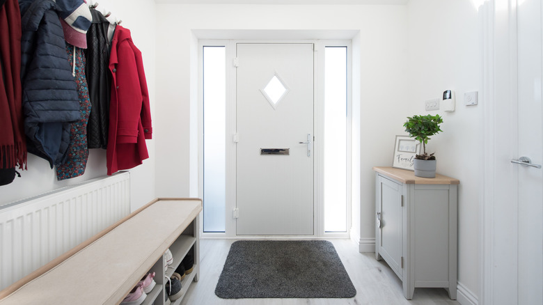 An entryway with white front door and seating