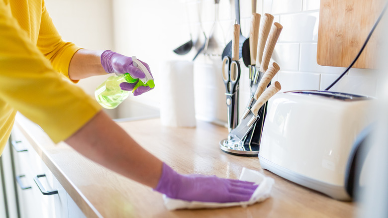 Woman cleaning kitchen countertop