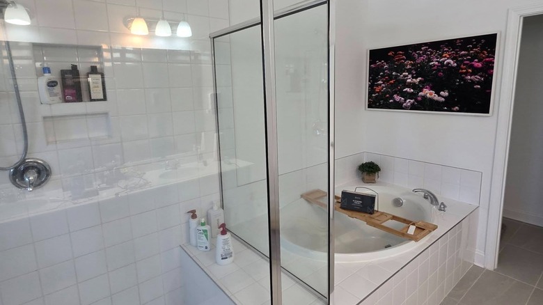 Samsung Fame TV above tub and shower combo in bathroom.