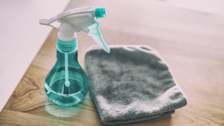 spray bottle and cloth on table