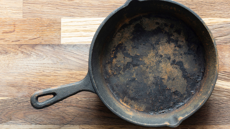 A dirty and rusted cast-iron pan