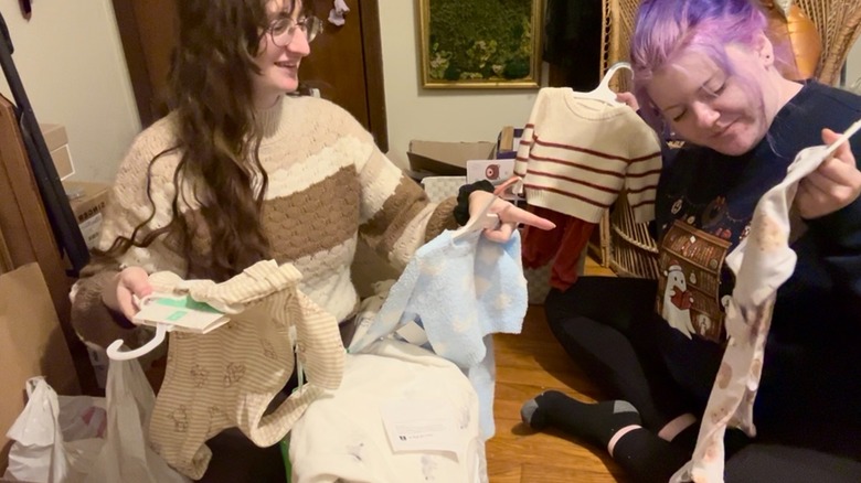 Amelia and friend decluttering baby clothes