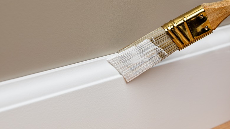 paint brush on base board with clean paint lines