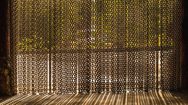 Iron chain curtain with sun shining through